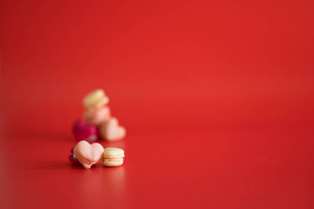 flat lay heart shape of macarons on red background