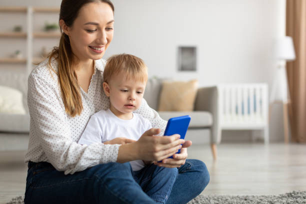 istock Kids and technologies. Happy mom and her son using smartphone, browsing new app or purchasing online 1370730109
