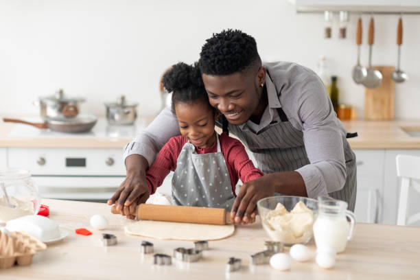 istock Loving black father rolling pastry dough with daughter 1370731332