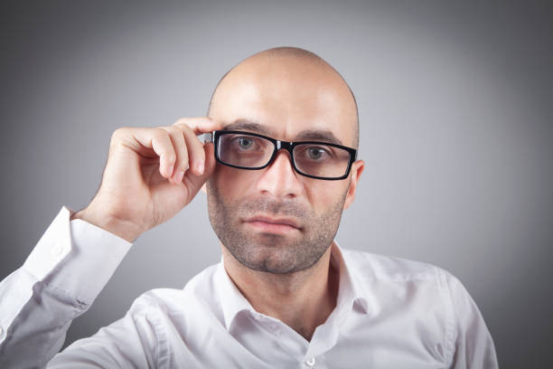 Close-up frontal portrait of young man with short red hair and beard. Neutral expression, brainless, expressionless and dumb. However, it could also be calm and cool-bloodedness of someone in control