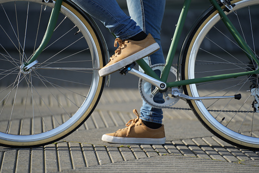 Closeup of feet  and wheels of urban bicycle.