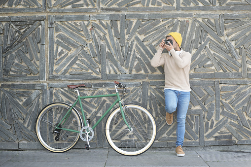 Content creator taking photograph beside bicycle