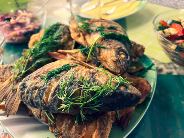 istock Sliced and fried fish with herbs on the plate. 1370734005
