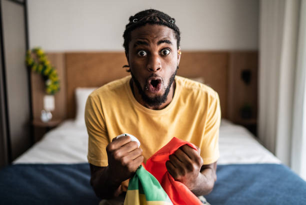 joven emocionado celebrando sosteniendo la bandera - house home interior flag usa fotografías e imágenes de stock