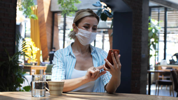istock Woman typing message writing on smart phone in a modern cafe. 1370736882