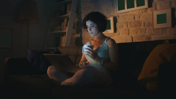istock Pretty woman is reading a message on the computer while sitting at her home. 1370737064