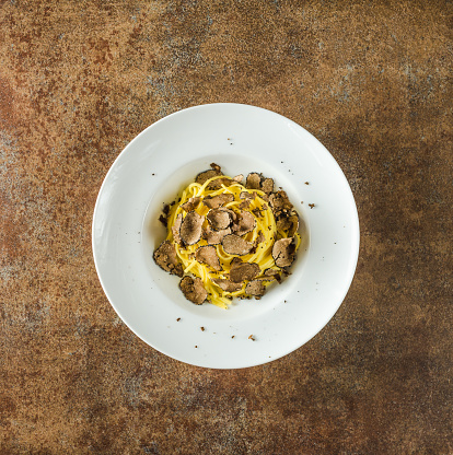 Pasta with truffles.Tagliatelle plate with truffle directly above copy space background.