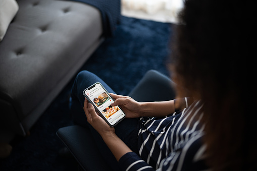 Couple ordering food online with smartphone at home