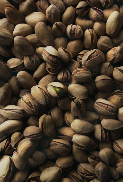 Top view of roasted pistachios on dark background.