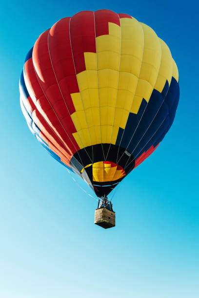istock Multicolored hot air balloon on blue sky close up vertical 1370737443