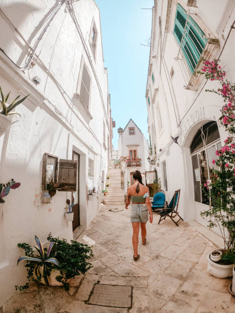 una giovane donna esplora un villaggio italiano nel sud italia - salento foto e immagini stock