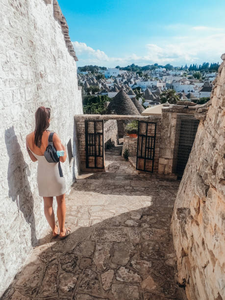 Young woman exploring the trulli houses in southern Italy The trulli, traditional Apulian dry stone hut with a conical roof alberobello stock pictures, royalty-free photos & images