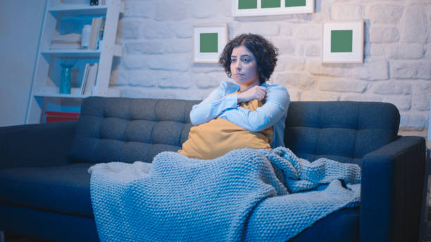 istock Young woman watching TV under the blanket. 1370739133