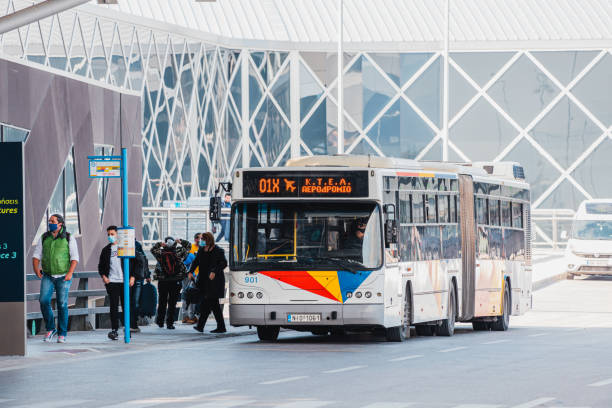 un bus régulier dépose les passagers à l’arrêt final à l’aéroport de thessalonique - car alarm photos et images de collection