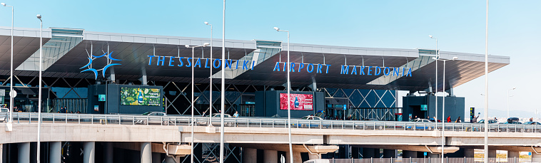 27 October 2021, Thessaloniki, Greece: Panorama of the airport terminal of Thessaloniki Macedonia with a road busy with cars and hurrying passengers