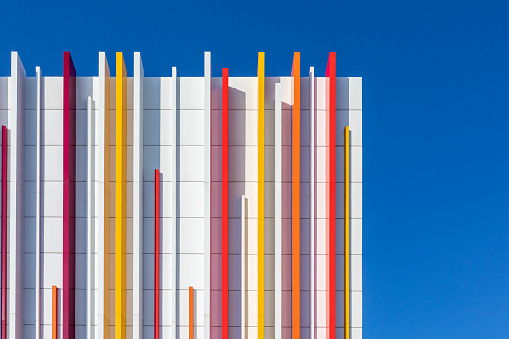 a fragment of a wall decorated with multicolored plastic on a blue sky background. Copy space