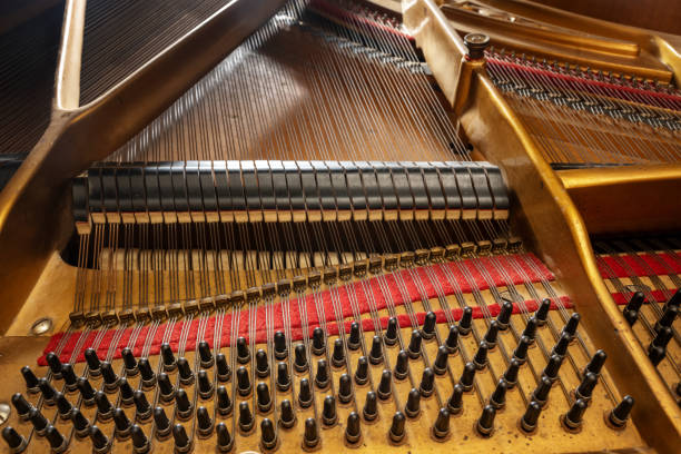 istock Inside an older grand piano with metal frame, strings, hammer, damper and red felt, mechanics of the acoustic musical instrument, music and culture concept, selected focus 1370745079