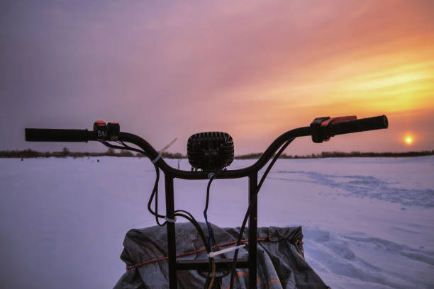 istock snowmobile steering wheel close-up at sunset background. 1370745362