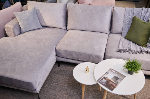 istock High angle view of a stylish comfortable sofa upholstered with light velour fabric with colorful pillows and a small journal table on display in the furniture store showroom 1370745752