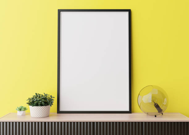 istock Empty vertical picture frame on yellow wall in modern living room. Mock up interior in minimalist, contemporary style. Free space for your picture, poster. Console, lamp. 3D rendering. Close up view. 1370746555