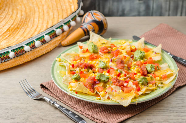 istock Nachos chips with cheese sauce, guacomole, salsa and vegetables on the plate. Serving in a restaurant. Mexican food concept. 1370746599