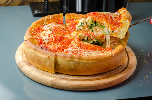 Chicago pizza with salmon, spinach, broccoli, mozzarella cheese, branded peeled tomato sauce and parmesan