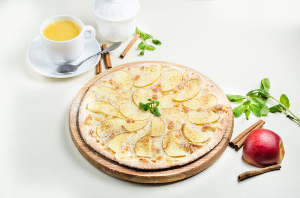 istock Sweet pizza with apples, cinnamon and mint on a light background 1370746661
