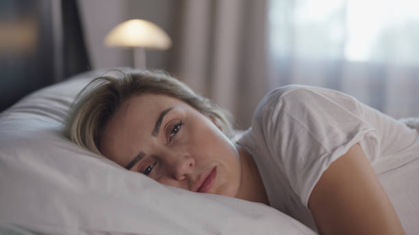 beautiful woman sleeping peacefully in her bed. woman wakes up and stretches. - moe stockfoto's en -beelden