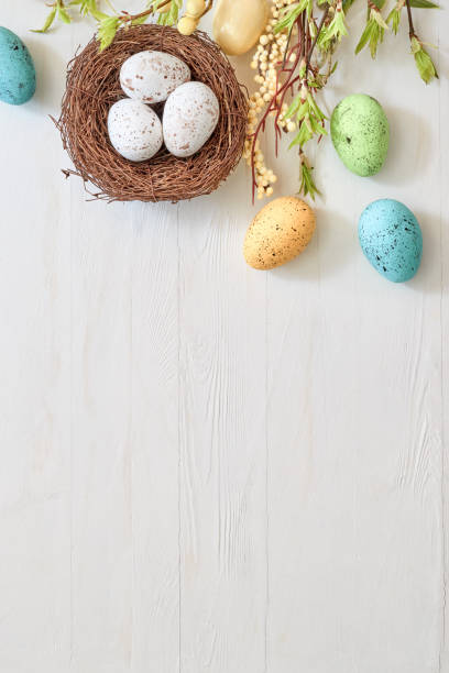 istock Branches with green leaves and easter eggs on a light background. Happy easter flat lay concept 1370748360