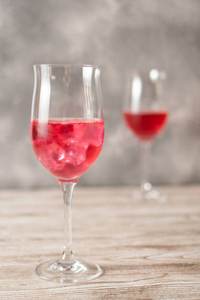 istock Two glasses of rose cocktails. Sparkling red cocktail with ice made at home. Vertical image. Homemade red cocktails 1370749708