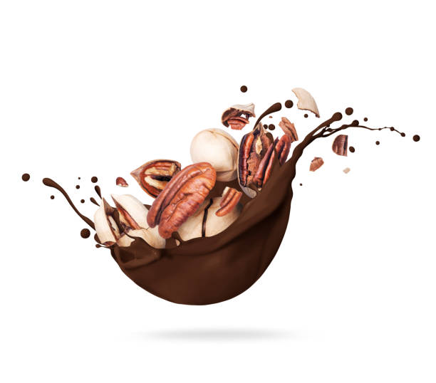 istock Dried crushed pecan nuts in chocolate splashes isolated on white background 1370751839