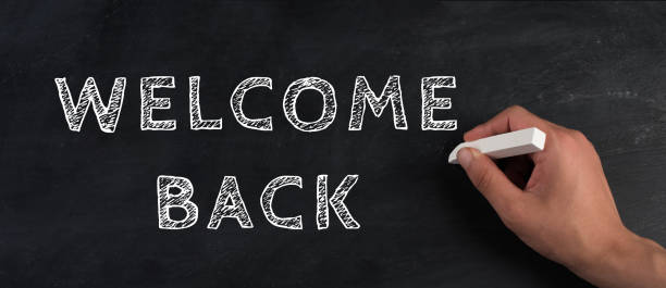 The words welcome back are standing on a chalkboard, reopen post covid-19 pandemic, back to normal, community stock photo