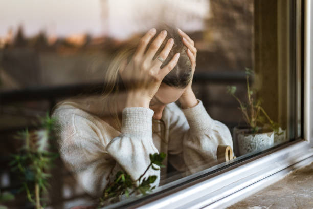 Young woman in depression Young woman in depression. Portrait of her through a window. face down stock pictures, royalty-free photos & images