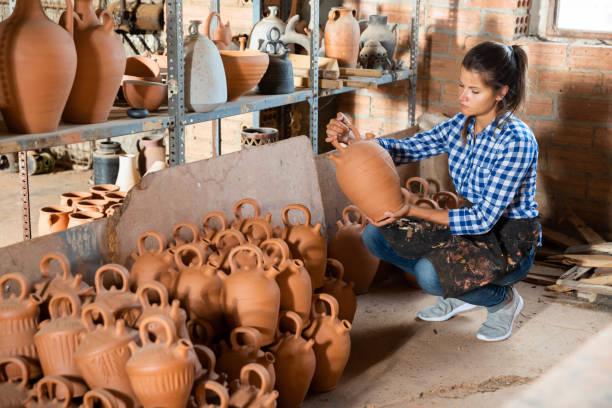 istock Female potter inspecting ceramics 1370754426