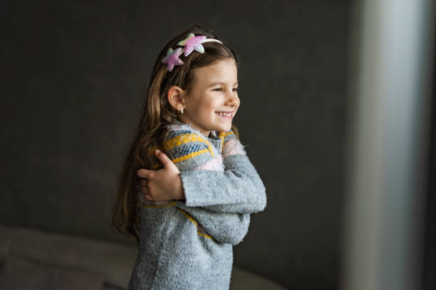 Smiling loving young girl hugging oneself