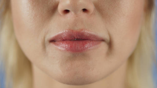 istock Sensual woman biting and licking plump lips. 1370756701