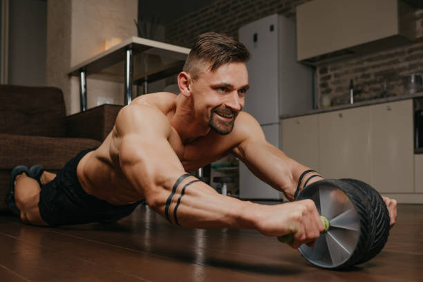 istock A bodybuilder with tattoos on his forearms is training with ab wheel at home 1370762802