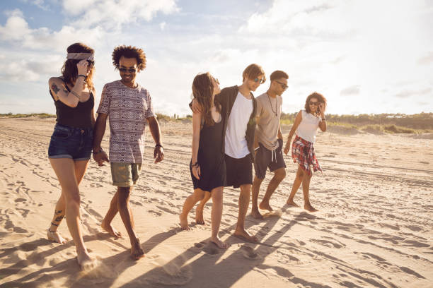 istock Multiethnic group of friends walking on the beach 1370763174