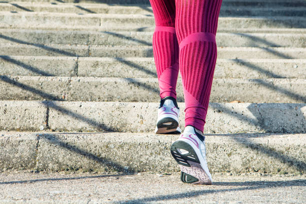 Young black woman exercising, running up steps