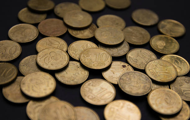Euro coins of ten cents Close-up photography of a bunch of euro coins of ten cents on a black background. ten cents stock pictures, royalty-free photos & images