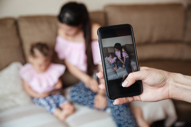 istock Mother with daughter sitting while anyone photographing their 1370767348