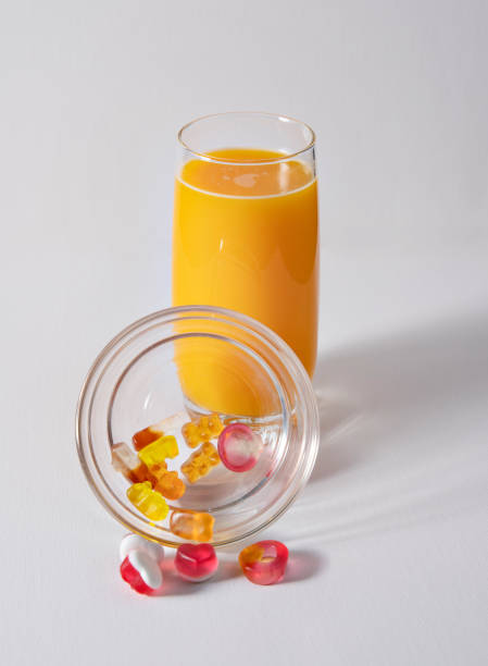 istock orange juice and Haribo candy on white background 1370768340