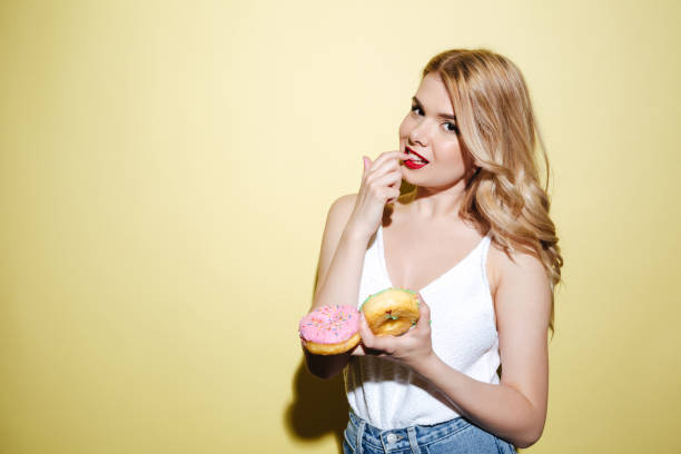 istock Woman with bright lips makeup holding donuts. 1370768412