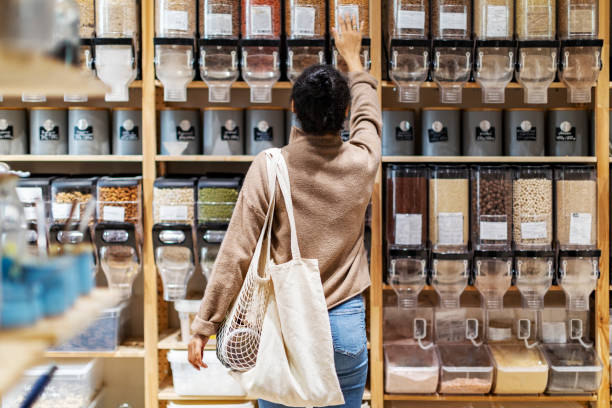 Young African woman shopping in zero waste store Young African woman shopping in zero waste store reusable bag stock pictures, royalty-free photos & images