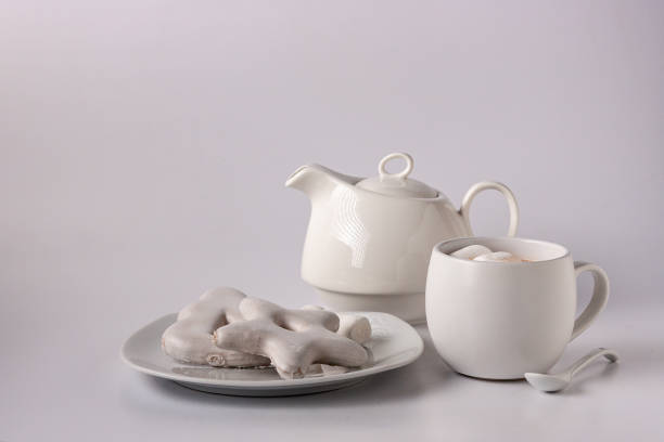 istock gingerbread cookies in white glaze, white teapot, cocoa in a cup on a white background copy space 1370774896