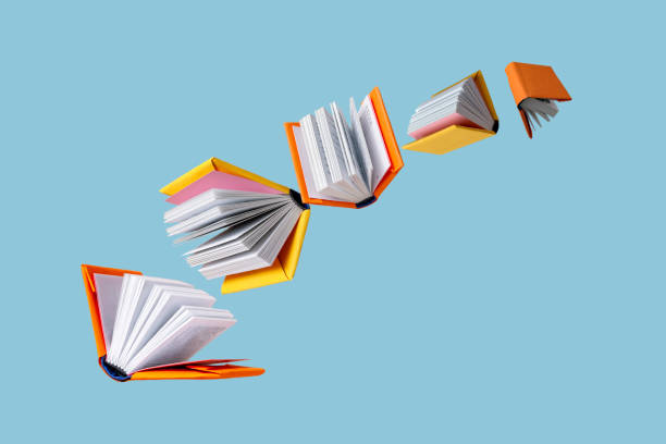 istock books in colored covers swirl on a blue background, copy space 1370774902