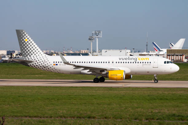 vueling passenger plane at airport. schedule flight travel. aviation and aircraft. air transport. global international transportation. fly and flying. - airplane airbus boeing air vehicle imagens e fotografias de stock