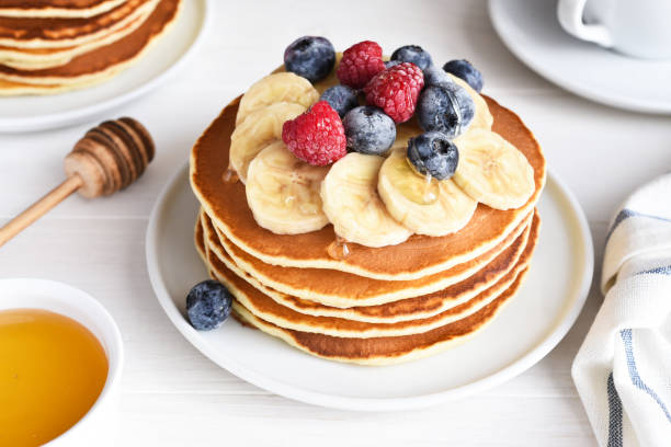 istock Stack of pancakes with berries and syrup on a kitchen table for breakfast. Good morning 1370776433