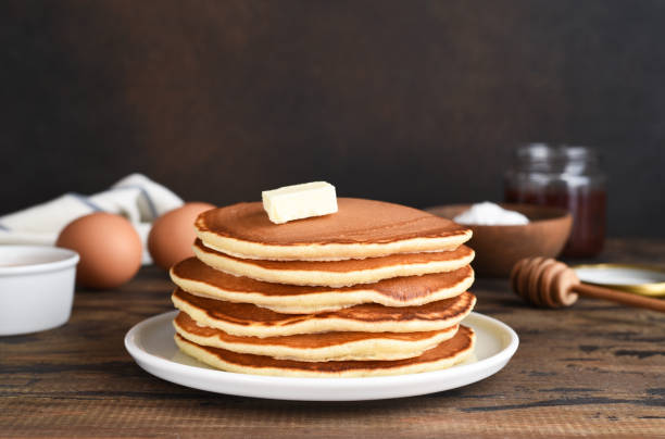 istock Blini or pancakes stack on wooden table with butter.  Maslenitsa holiday concept. Rustic style breakfast 1370776586