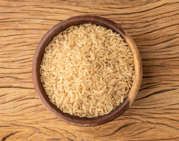 istock Raw brown whole rice in a bowl over wooden table 1370777519